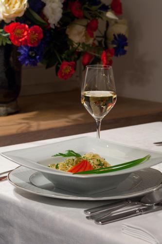 a plate of food and a glass of wine on a table at Dwór na Wolicy in Dębica