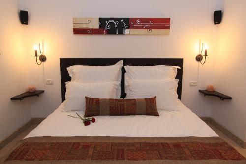 a bedroom with a bed with white sheets and pillows at Volcanes in Had Nes