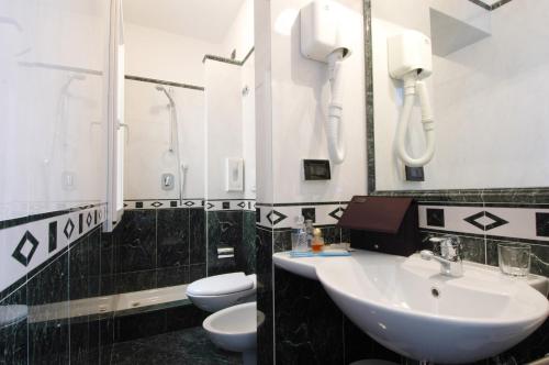 a bathroom with a sink and a toilet and a phone at Hotel Palazzo Vecchio in Florence