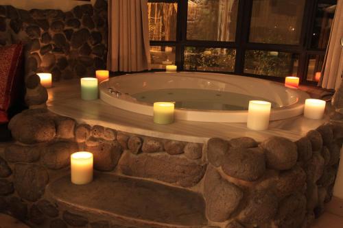 uma banheira com velas num quarto em Volcanes em Had Nes