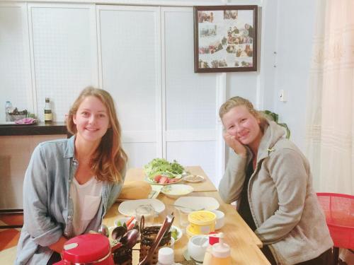 twee vrouwen aan een tafel met een bord eten bij Nhat Son Guesthouse in Lạng Sơn