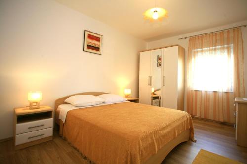 een slaapkamer met een bed met 2 lampen op een nachtkastje bij Dunato in Krk