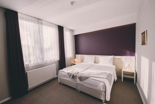 a bedroom with a large bed and a large window at Hotel Nova Bentbaša in Sarajevo