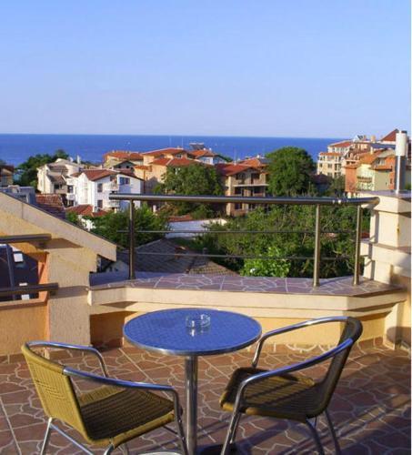 a patio with a table and two chairs on a balcony at Hotel Hawaii in Lozenets