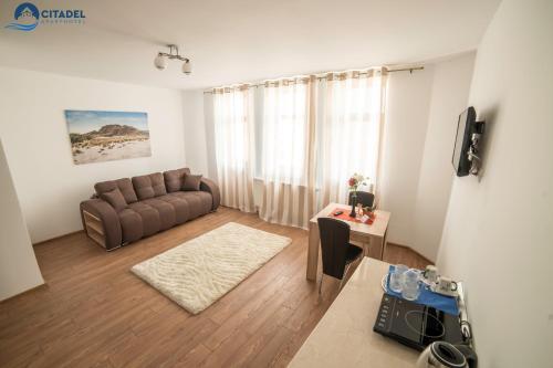 - un salon avec un canapé et une table dans l'établissement Citadel Aparthotel, à Galaţi