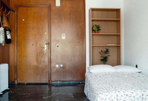 アテネにあるTop floor studio with endless viewのベッドルーム1室(ベッド1台付)、木製のドア