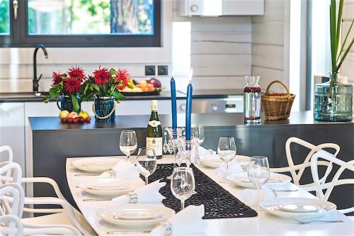 a table with white plates and wine glasses on it at Hapsal Spa Villas in Haapsalu