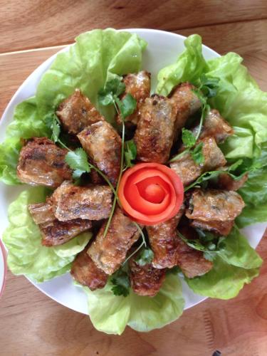 a plate of food with lettuce and a tomato at Green Hill Hostel & Tour in Ha Giang