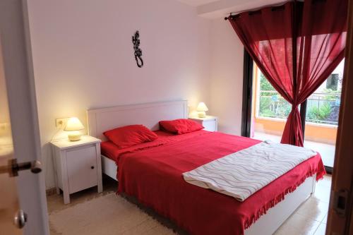 リョレート・デ・マルにあるApartment Iliaのベッドルーム1室(赤いシーツ付きのベッド1台、窓付)