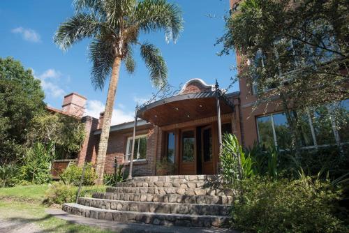 a house with a palm tree in front of it at Don Numas Posada & Spa in San Lorenzo