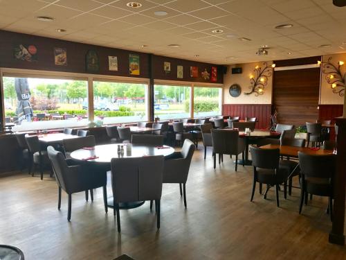 a dining room with tables and chairs in a restaurant at Hotel de Raket in Rogat