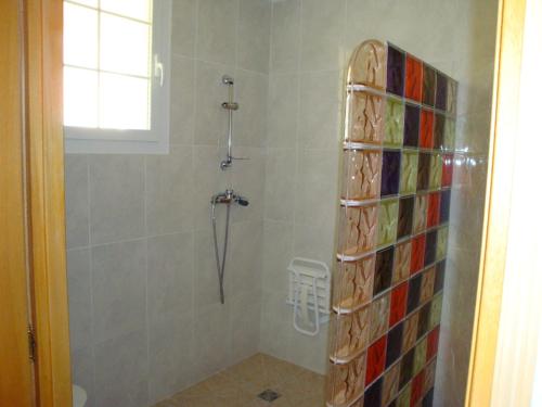 baño con ducha y puerta de cristal en Hôtel Camparellu en Galeria
