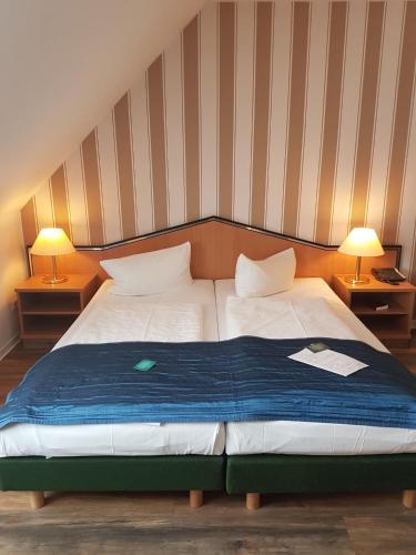 two beds in a room with two lamps on tables at Residenz Hotel Leipzig in Leipzig