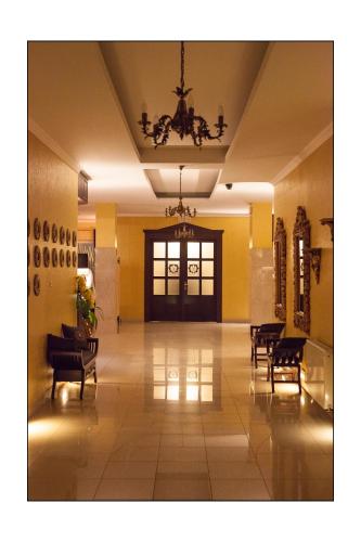 a hallway with chairs and a chandelier in a building at Hotel Lord Dębica in Dębica