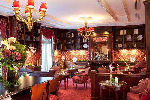 un restaurant avec des tables et des chaises et un lustre dans l'établissement Auberge du Jeu de Paume, à Chantilly
