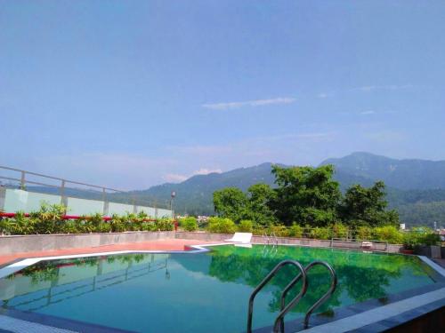a swimming pool with a view of the mountains at Hotel Natraj Rishikesh in Rishīkesh