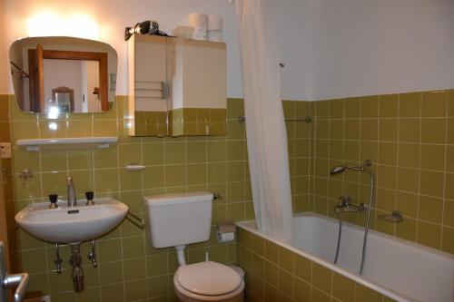 a bathroom with a toilet and a sink and a tub at Bruyères B22 in Verbier