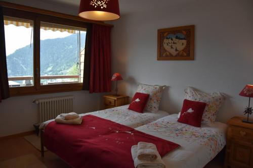 a bedroom with two beds with red pillows at Bruyères B22 in Verbier