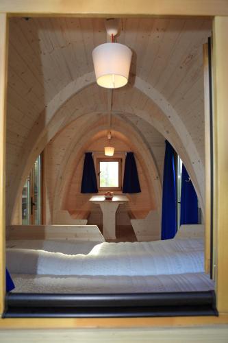 a bedroom with a large bed in a room with a window at Trekkershut in Jubbega-Schurega