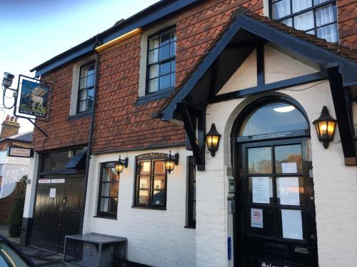 a building with an archway in front of it at The White Hart pub and rooms in Cranleigh