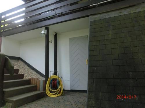 a garage with a yellow hose next to a door at Ferienhaus im Ederbergland in Hatzfeld