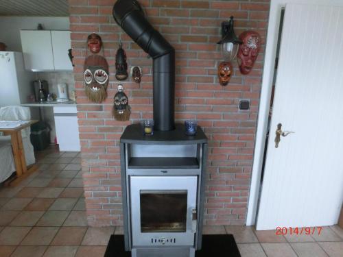 a stove in a kitchen with a brick wall at Ferienhaus im Ederbergland in Hatzfeld