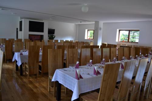 a dining room with tables and chairs with white tablecloths at Mountain-Rest Pension in Miercurea-Ciuc