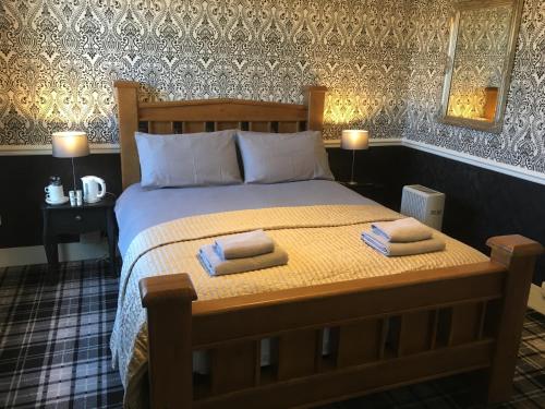 ein Schlafzimmer mit einem Bett mit zwei Handtüchern darauf in der Unterkunft The White Hart pub and rooms in Cranleigh
