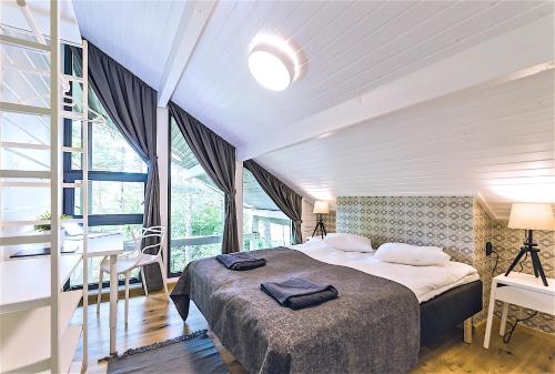 Hapsal Spa Villas في هابسالو: غرفة نوم بسرير كبير ونافذة كبيرة