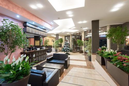 a lobby with potted plants and a christmas tree at Hotel Bellevue - Half Board in Pamporovo