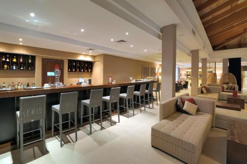 
a living room filled with furniture and a bar at Vincci Resort Costa Golf in Chiclana de la Frontera
