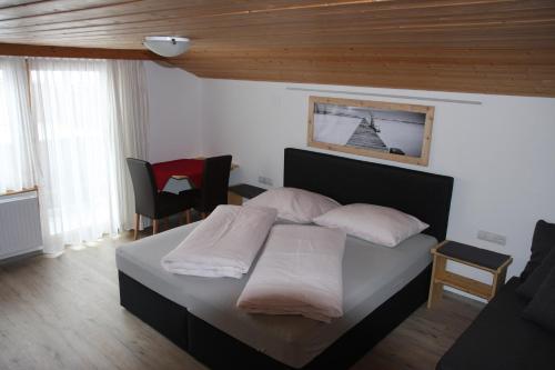 a bedroom with a bed with white pillows at Haus Eckhart in Kaunertal