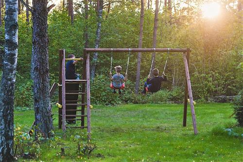 a group of children playing on a swing set in a park at Hapsal Spa Villas in Haapsalu