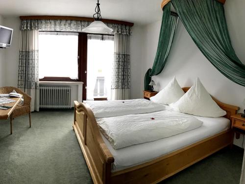 a bedroom with a large bed with a green canopy at Gästehaus Pointner in Ruhpolding