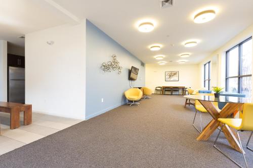 an office with yellow chairs and a table and a tablektop at Sage Apartments Boston Logan Airport Chelsea in Chelsea
