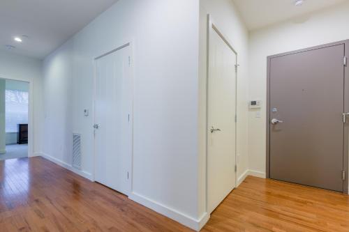 an empty room with two doors and wood floors at Sage Apartments Boston Logan Airport Chelsea in Chelsea