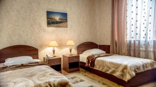 Cette chambre comprend 2 lits et une fenêtre. dans l'établissement Hotel Magnoliya, à Rostov-sur-le-Don