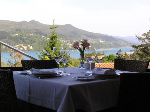 a table with wine glasses and a view of the ocean at Bungalows Portuondo parking gratuito in Mundaka