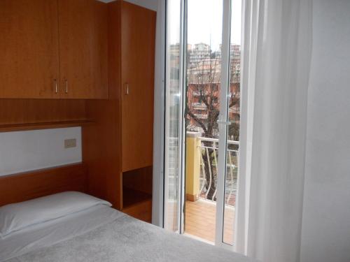 a bedroom with a bed and a large window at Hotel Arcobaleno in Celle Ligure