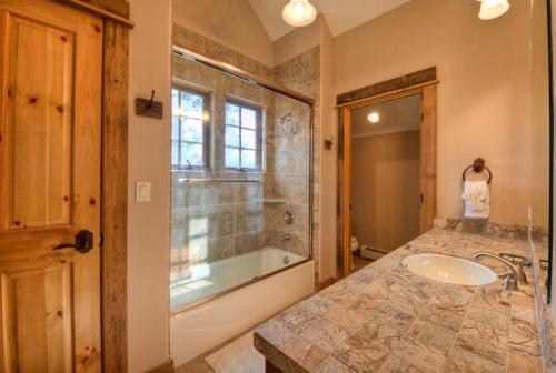 a bathroom with a tub and a sink at Antler Ridge Lodge in Big Sky