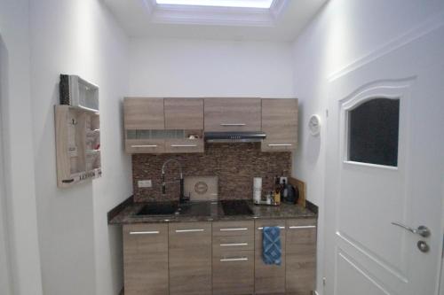 a kitchen with wooden cabinets and a sink at Pension / Zimmervermietung Wasbek in Wasbek
