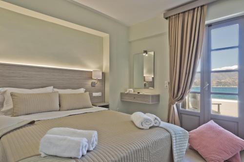 a bedroom with a bed with towels on it at Nereus Luxurious Suites in Karpathos Town