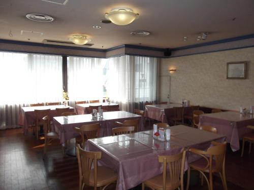 a dining room with tables and chairs with pink tablecloths at Ichikawa Grand Hotel in Ichikawa