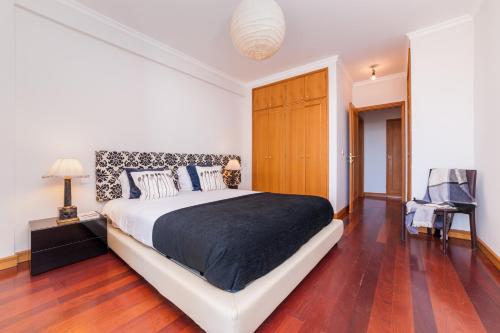 1 dormitorio con 1 cama grande y suelo de madera en Falesia Apartment by LovelyStay, en Funchal