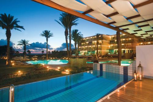 uma vista para uma piscina de resort à noite em Constantinou Bros Asimina Suites Hotel em Pafos