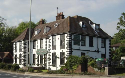 a large white building with a brown roof at The Roundabout Hotel in Fareham