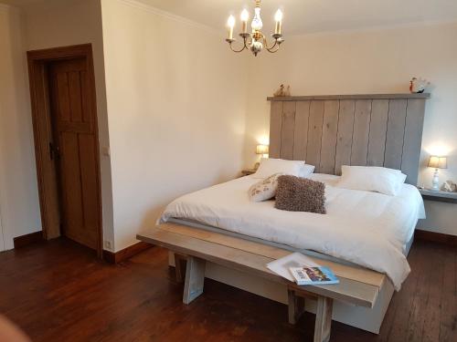Schlafzimmer mit einem großen weißen Bett mit einem Kopfteil aus Holz in der Unterkunft Widdingenhof in Wellen