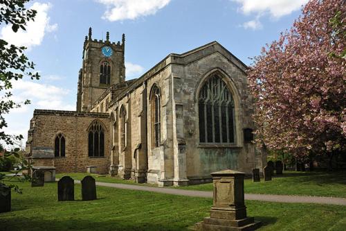 an old church with a clock tower in the grass at Wolds Cottage Pocklington in Pocklington