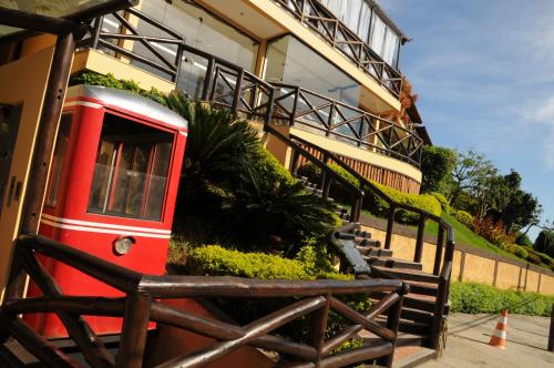 a red train is parked next to a building at Rio Búzios Beach Hotel in Búzios