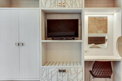 a living room with a tv in a white cabinet at Hotel Dolcevita in Cesenatico